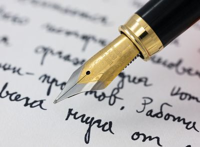A fountain pen nib resting on a handwritten page